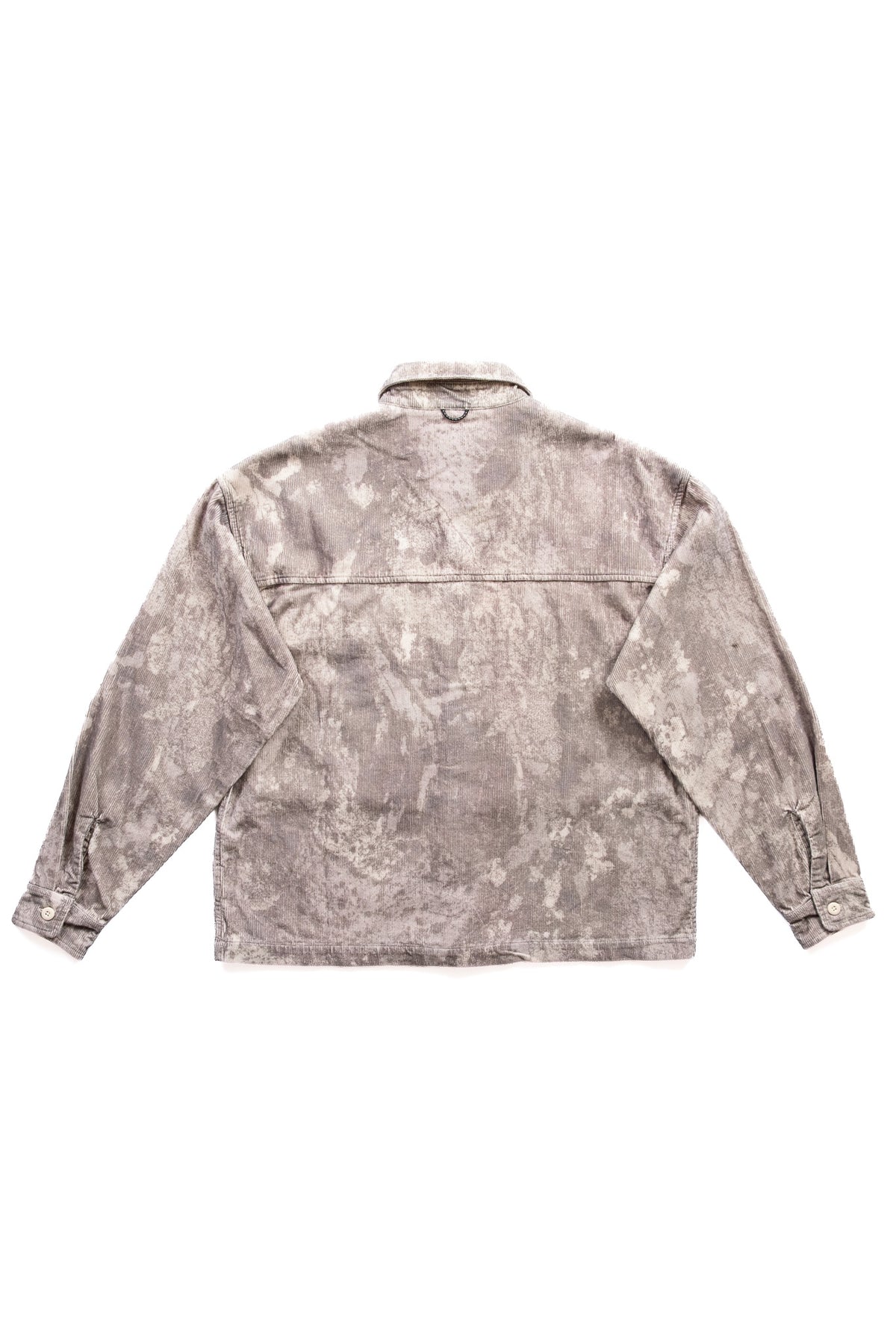 A boxy long-sleeve jacket with a mottled, winter camouflage finish in shades of gray, and beige, shown from the back against a plain white background.