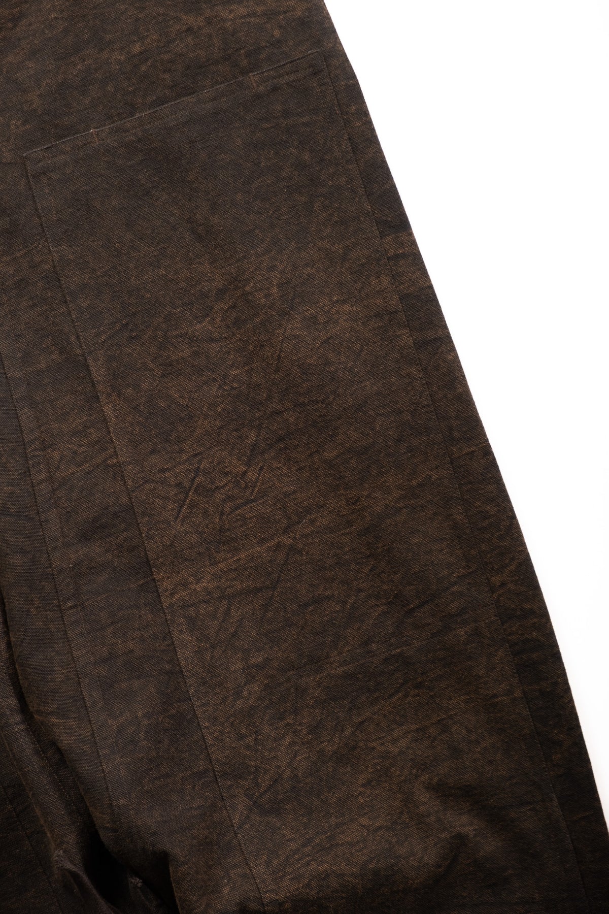 Close-up of textured fabric with a subtle distressed or cracked finish, shown against a white background.