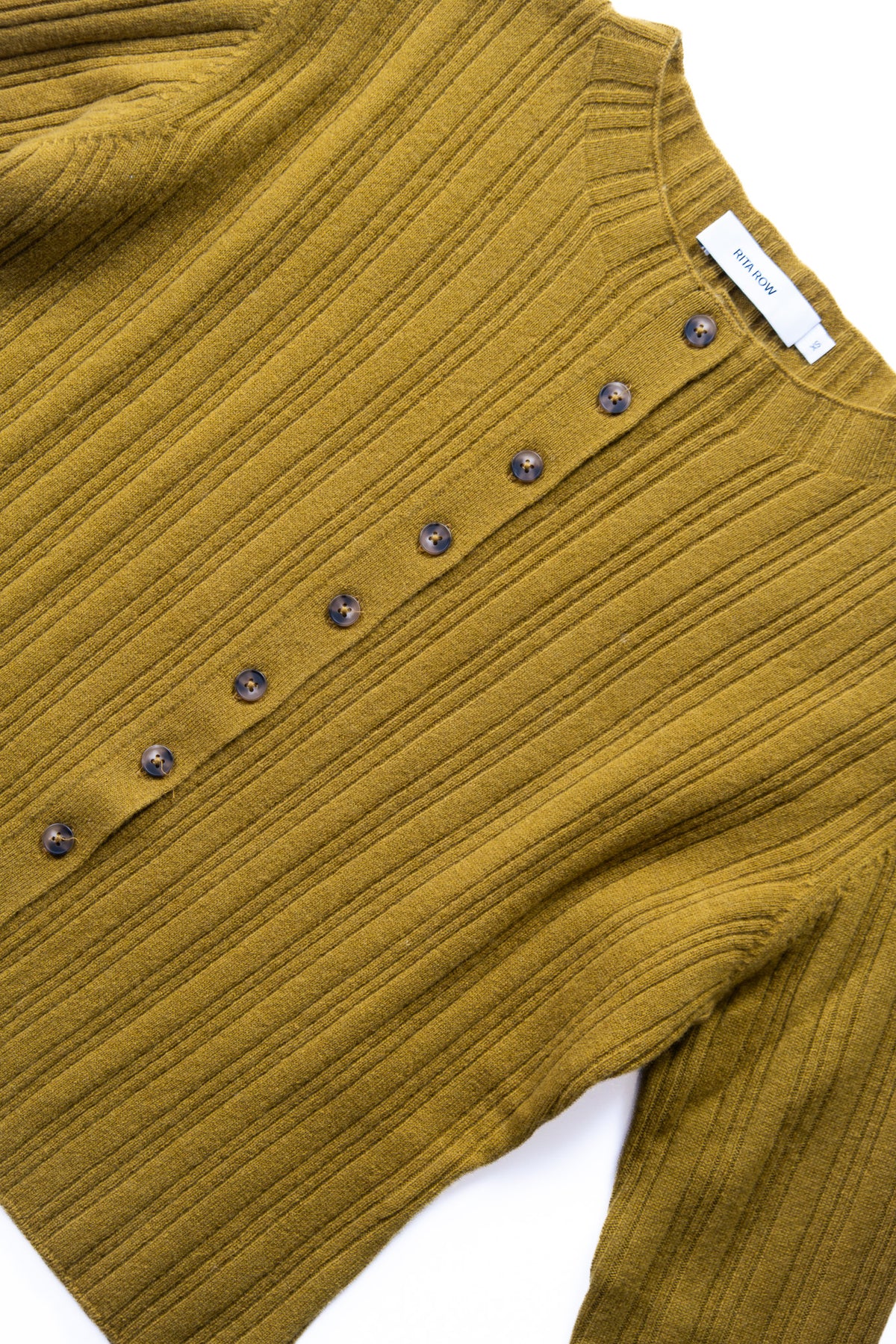 Close-up of a ribbed knit sweater in a warm green yellow color, featuring a row of dark buttons down the front.