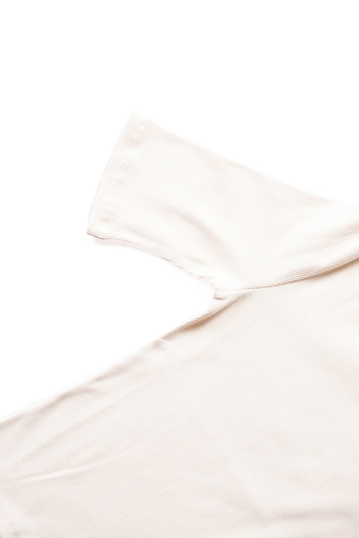 A close-up of a light cream ribbed knit fabric, showing the texture against a solid white background.