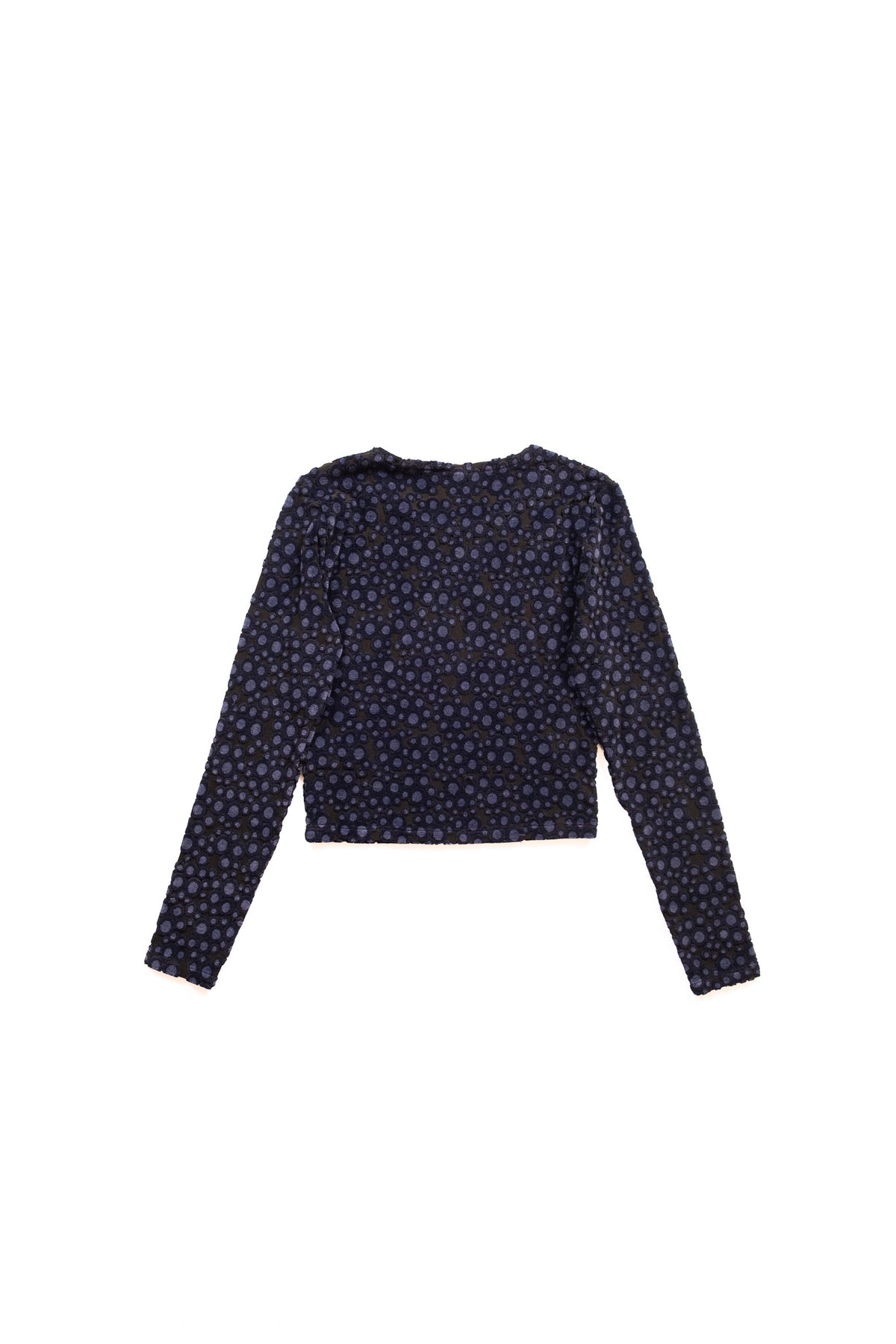 A long-sleeve cropped top with a dense small-scale polka dot print in navy blue and blakc, displayed flat against a solid white background.