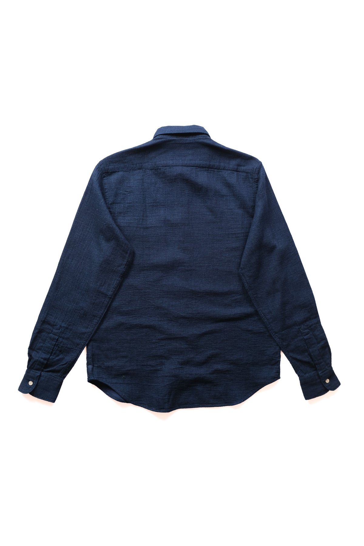 A dark indigo blue long-sleeve button-up shirt shown from the back, laid flat on a clean white background.