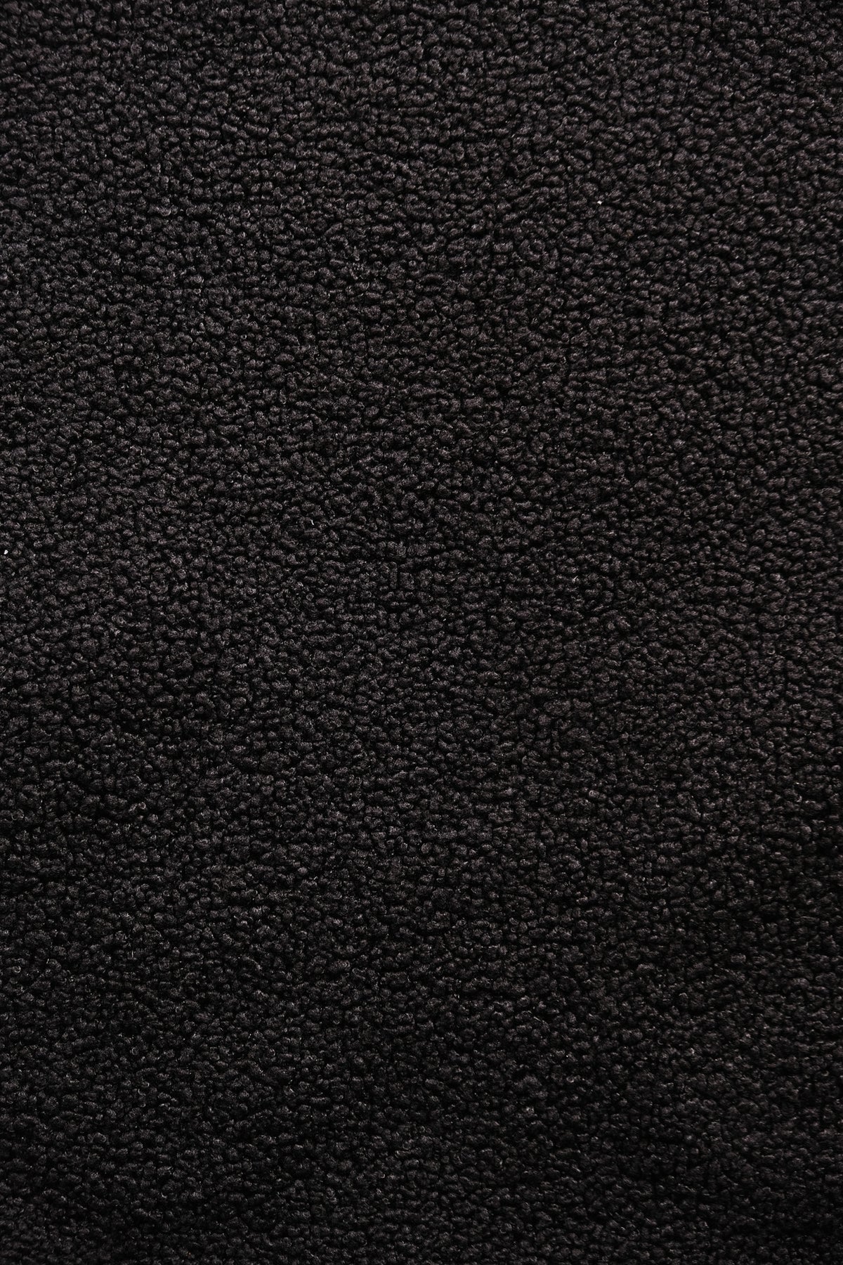 A close-up texture shot of a black fleece fabric surface, filling the entire frame.
