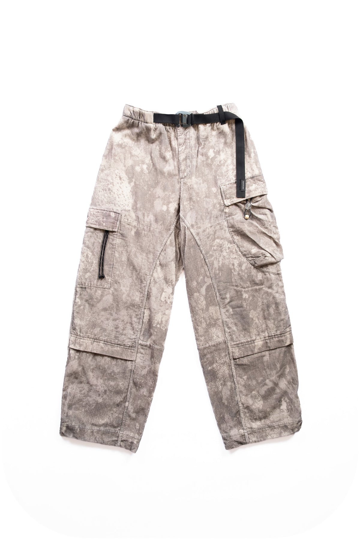 A pair of cargo pants featuring a mottled, winter camo-esque pattern in beige and gray, with a black waist belt and black zipper details, laid flat on a white background.