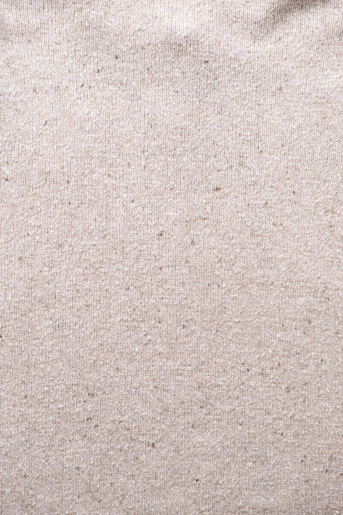 A close-up of a textured fabric swatch in a taupe color with subtle brown and gray flecks throughout.