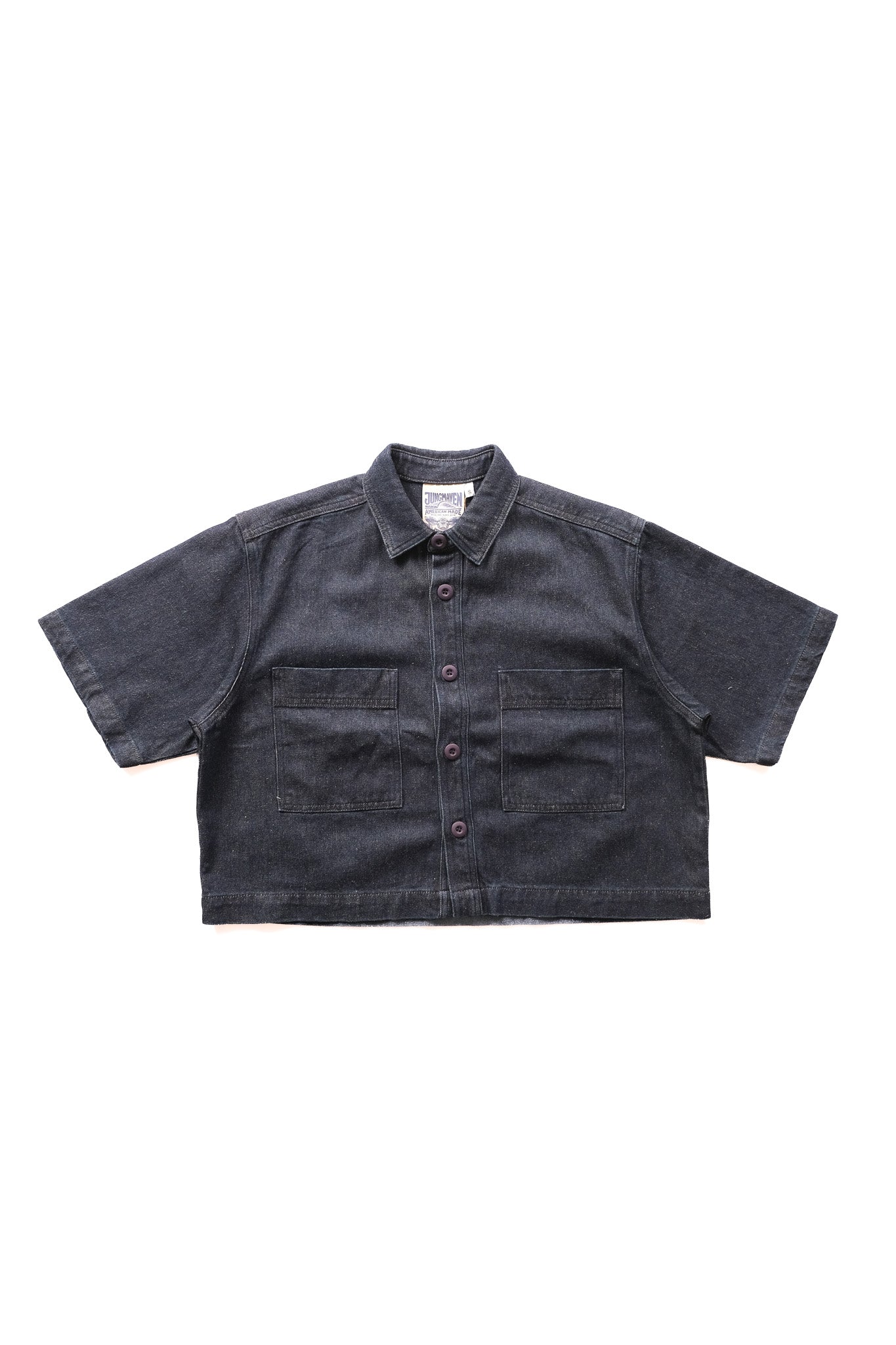 A dark denim short-sleeve button-up shirt with two front chest pockets, laid flat against a solid white background.