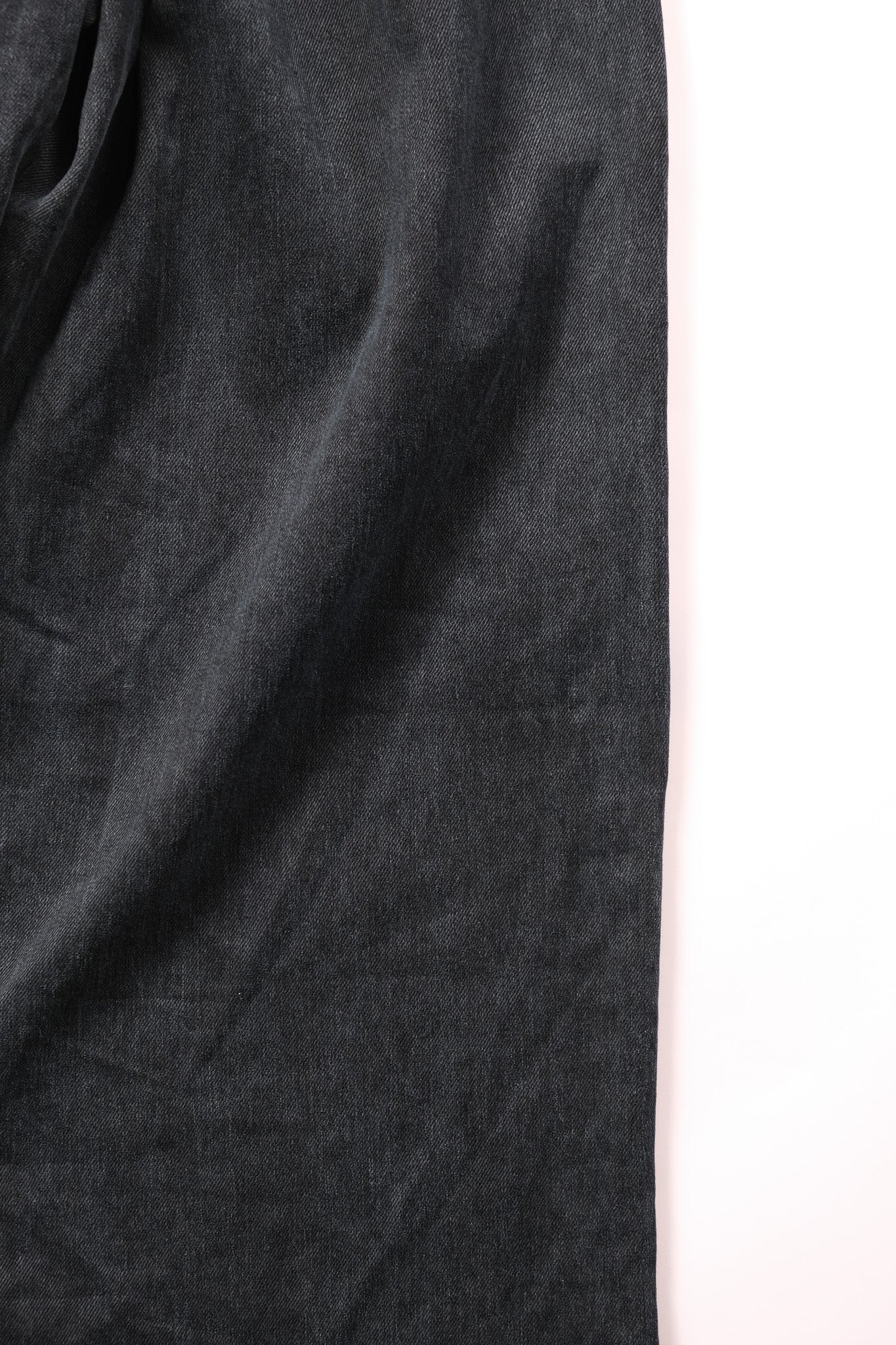 A close-up of  fabric with soft folds, shown next to a plain white background.