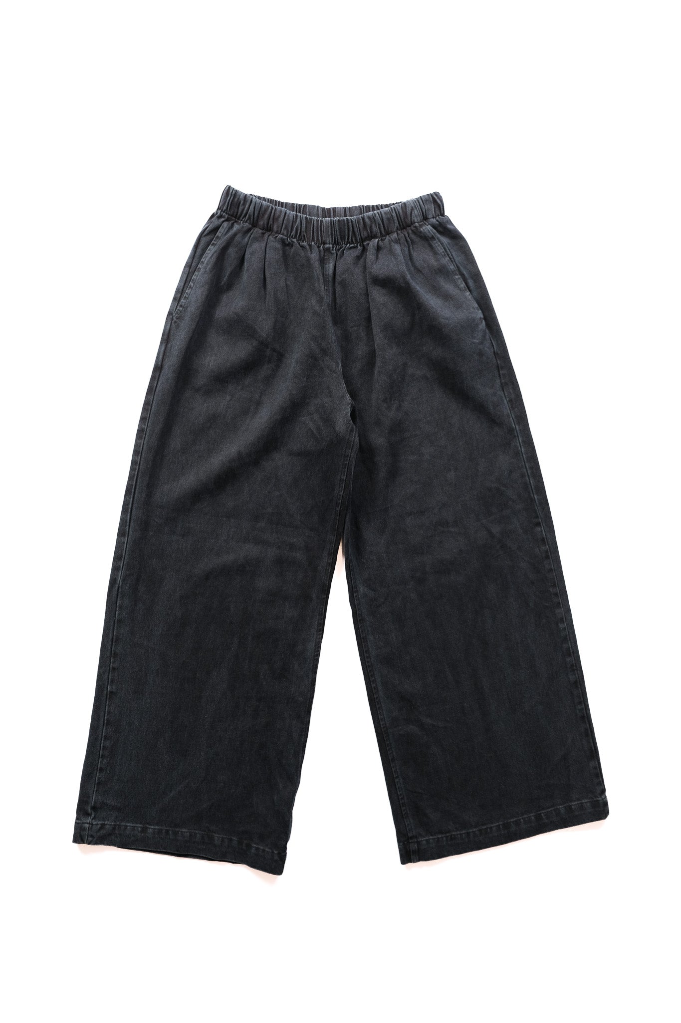 Black indigo wide-leg pants with an elastic waistband, laid flat on a white background.
