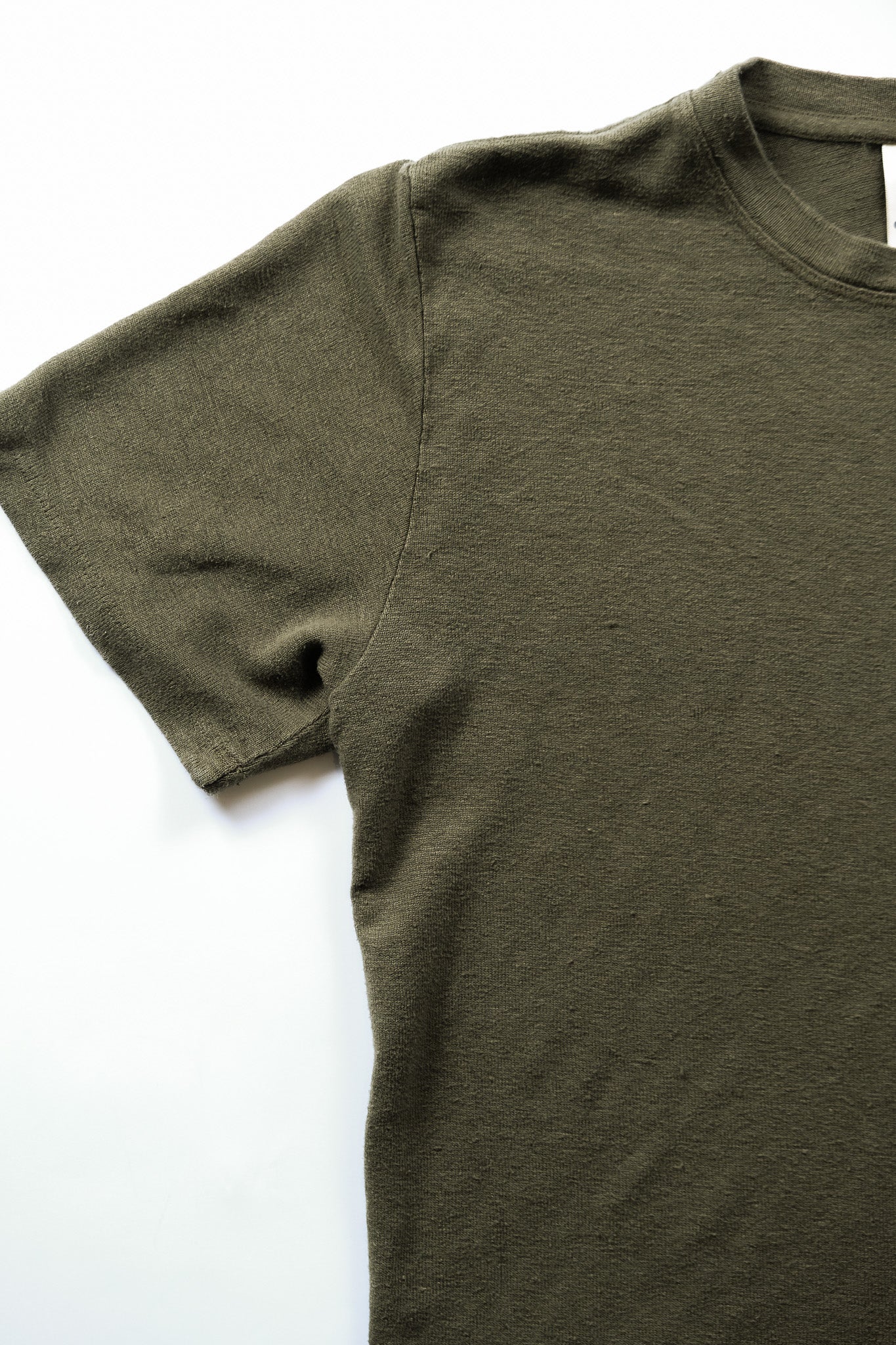 close up sleeve detail of olive tshirt 
