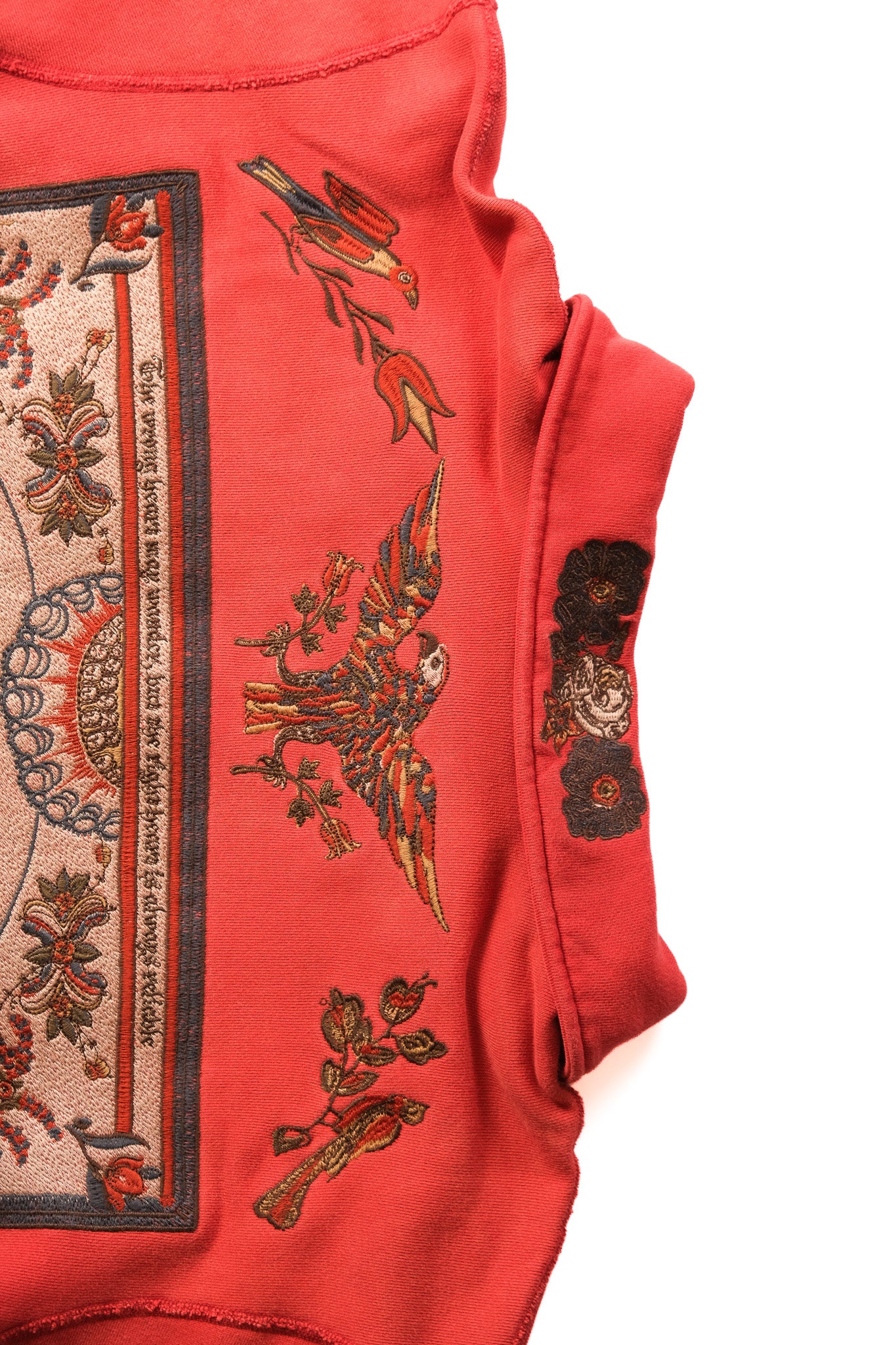 close up of collar of red quarter zip featuring birds and floral imagery 